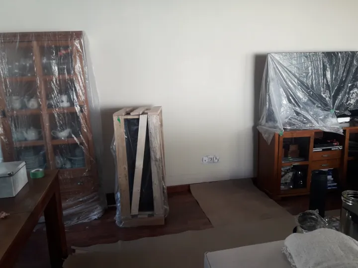 Salón con los muebles protegidos antes de instalar la estufa