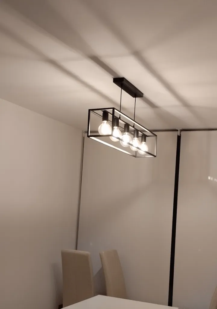 Lámpara de techo de cinco bombillas instalada sobre la mesa de comedor